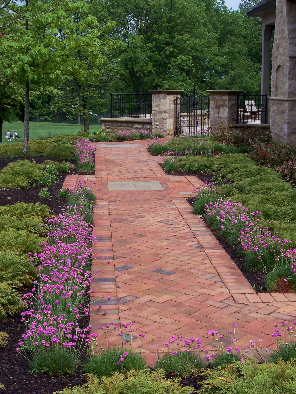 Brick garden walk bordered by flowering planting beds